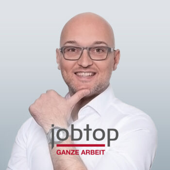 Mann mit Glatze und Brille fasst sich ans Kinn