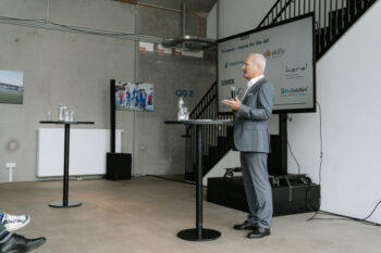 Mann mit Anzug spricht ins Mikrofon