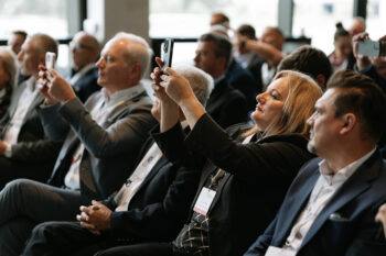 Menschen im Publikum halten Smartphones und machen Fotos