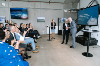 Zwei Männer schütteln sich die Hände auf der Bühne