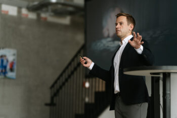 Mann im Anzug spricht auf der Bühne