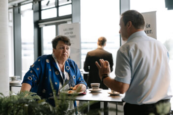 Frau und Mann unterhalten sich am Stehtisch