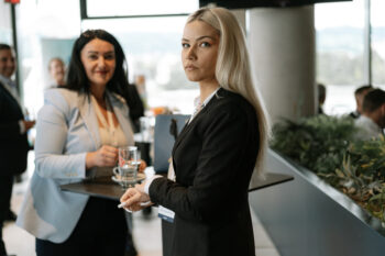 Frauen in Businesskleidung stehen am Stehtisch