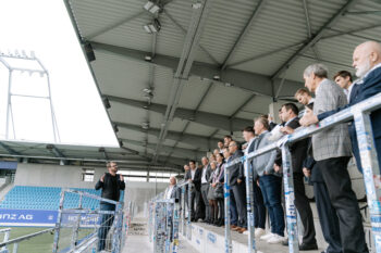 Menschen in Business Kleidung stehen auf der Stadiontribühne