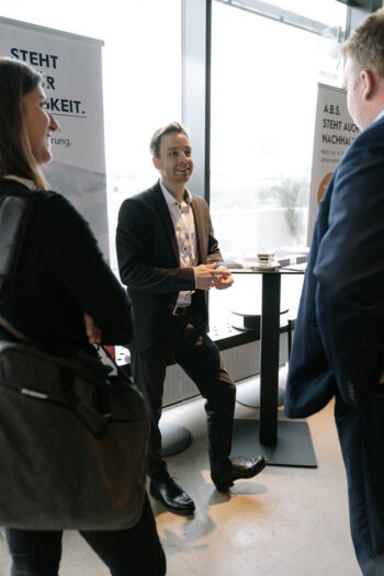 Gruppe mit Businesskleidung an Stehtisch