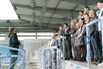 Menschen in Business Kleidung stehen auf der Stadiontribühne
